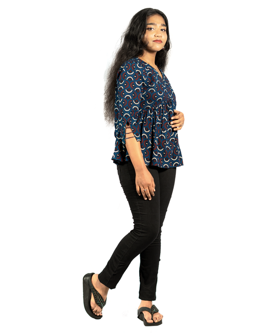 Woman wearing a blue printed Ajrakh Short Top For Women paired with black pants and sandals