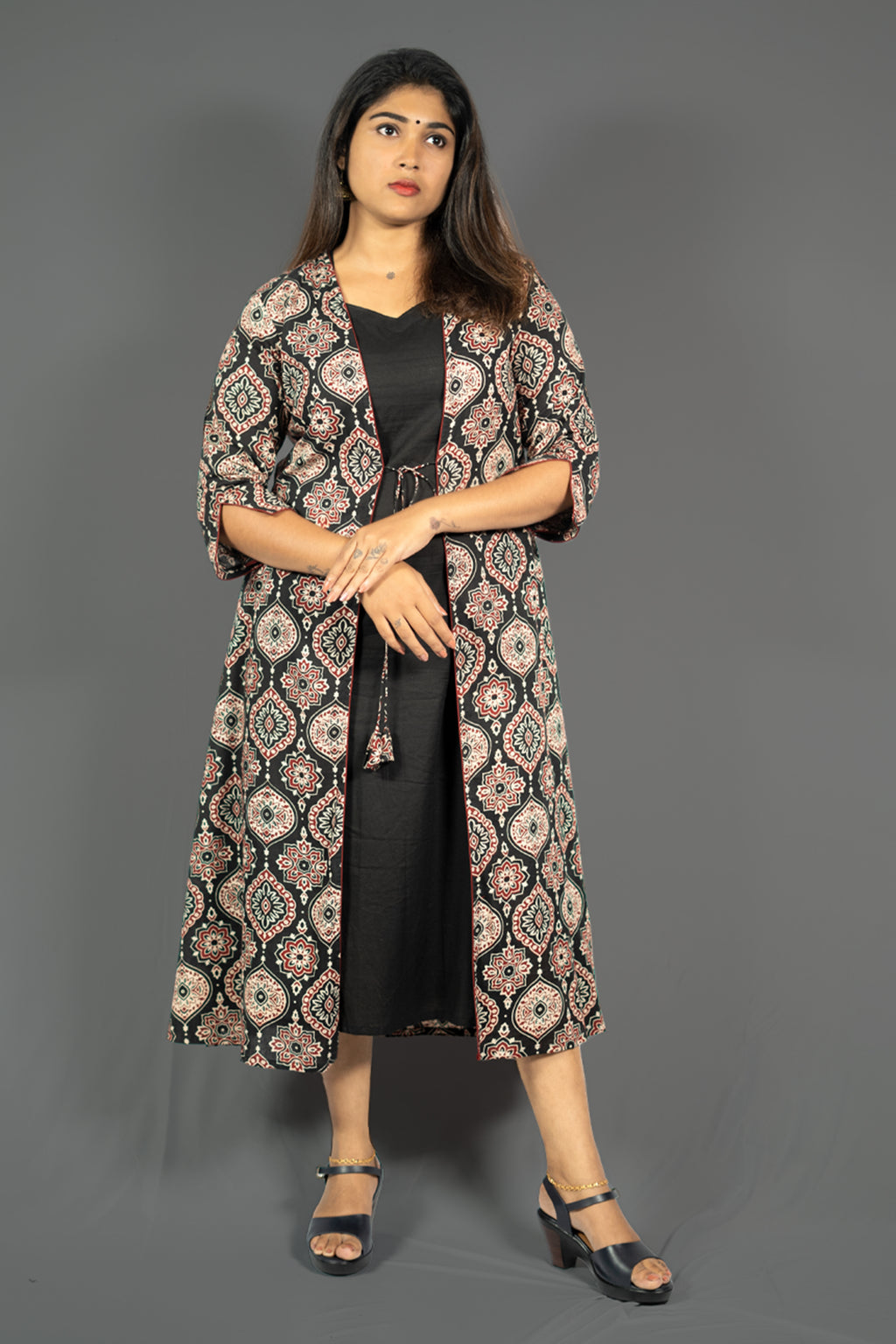 Black women's ethnic co-ord set featuring A-line dress with ornate patterned jacket and stylish sandals