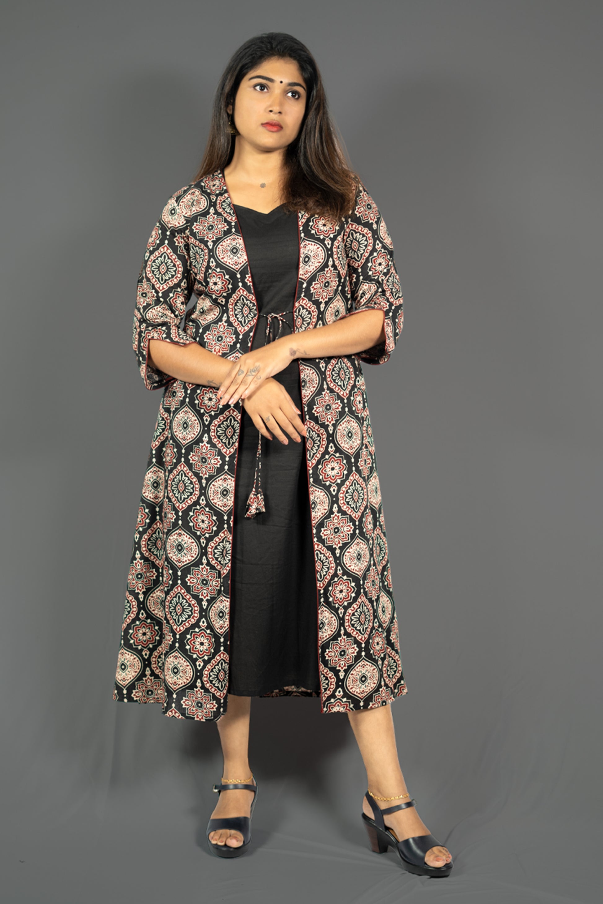 Black women's ethnic co-ord set featuring A-line dress with ornate patterned jacket and stylish sandals