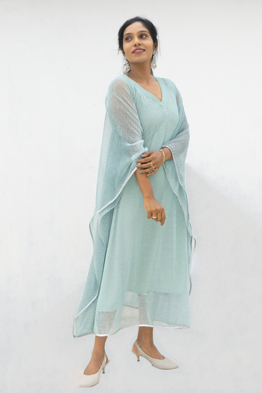 Woman wearing a light blue Modern Mesh Net Kaftan Outfit with sheer sleeves and beige heels