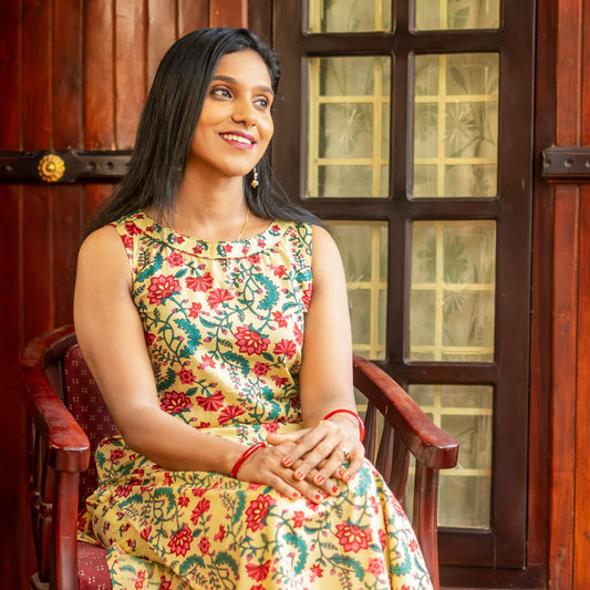 Woman wearing Jacinda women's ethnic coord set online with floral print sitting on wooden chair indoors