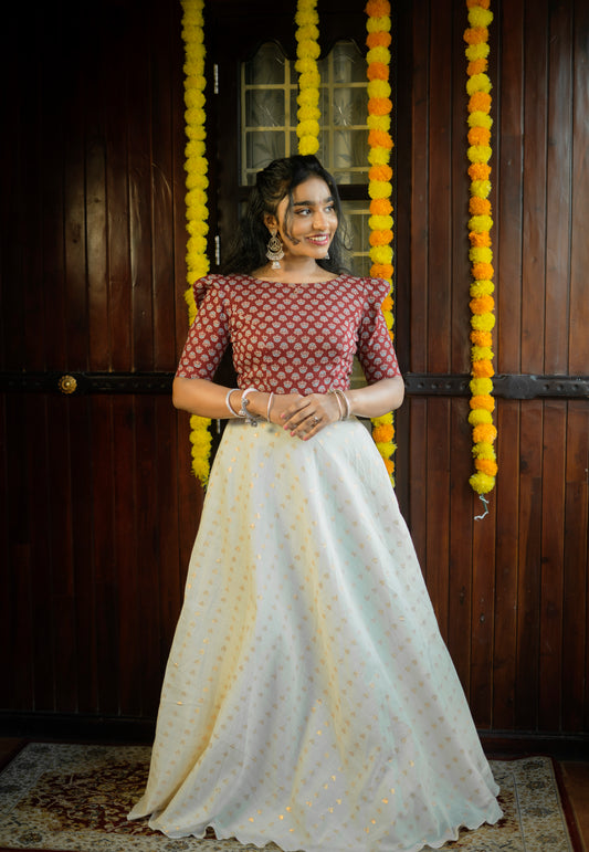 Women's red Ajrakh print crop top paired with a white skirt in a traditional festive setting